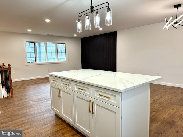 kitchen with white cabinets, a kitchen island, wood finished floors, and baseboards