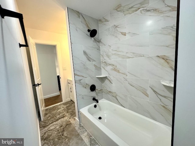 bathroom featuring baseboards, marble finish floor, and shower / washtub combination