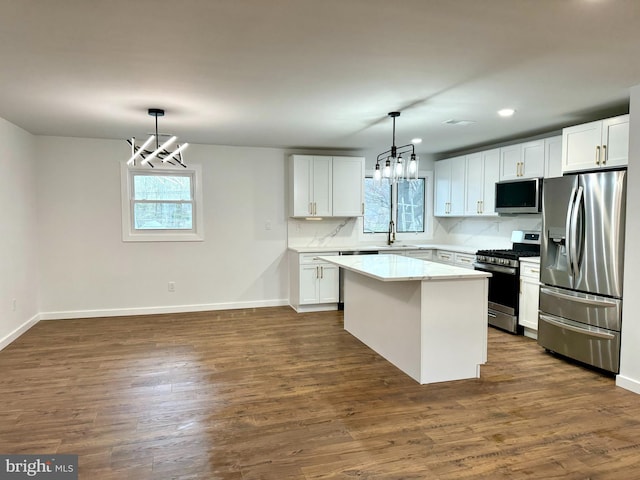 kitchen featuring a wealth of natural light, stainless steel appliances, a chandelier, and a sink