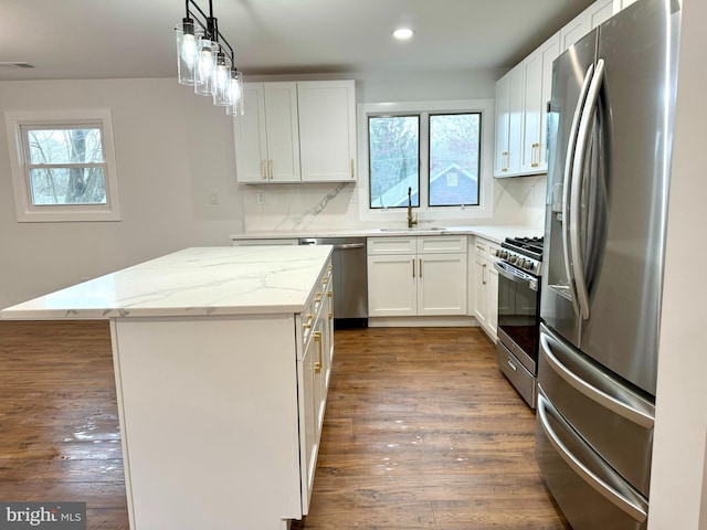 kitchen with a sink, dark wood-style flooring, a wealth of natural light, and appliances with stainless steel finishes