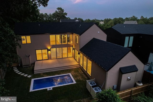 19690 Dunbar St, Rehoboth Beach, DE 19971 - back of property at dusk with a wooden deck and roof with shingles