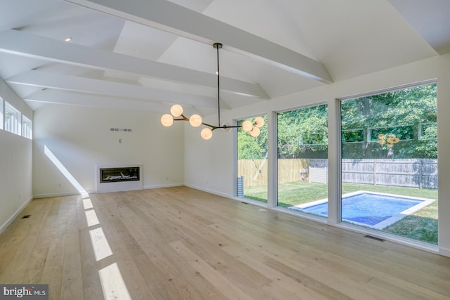 19690 Dunbar St, Rehoboth Beach, DE 19971 - unfurnished living room featuring light wood-style flooring, a chandelier, and a glass covered fireplace