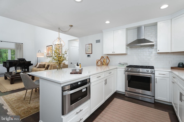 kitchen featuring a peninsula, light countertops, wall chimney exhaust hood, and stainless steel range with gas cooktop