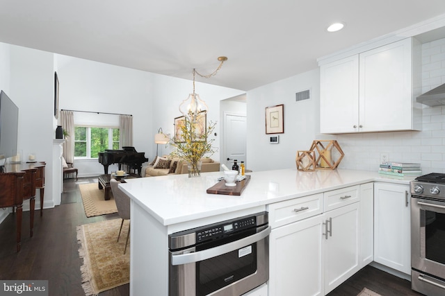 kitchen featuring light countertops, visible vents, a peninsula, and appliances with stainless steel finishes