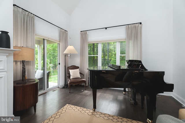 living area featuring visible vents, wood finished floors, a healthy amount of sunlight, and high vaulted ceiling