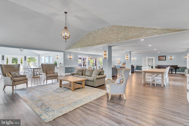living room featuring an inviting chandelier, wood finished floors, and high vaulted ceiling