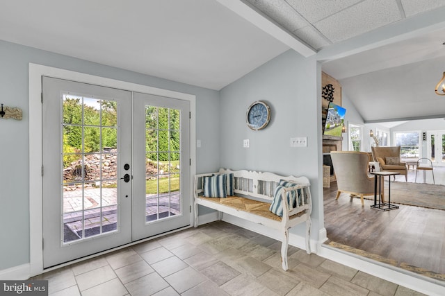 doorway featuring vaulted ceiling, baseboards, french doors, and plenty of natural light