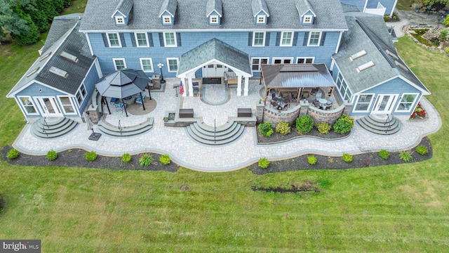 rear view of property featuring a patio area, a gazebo, a lawn, and outdoor dining space