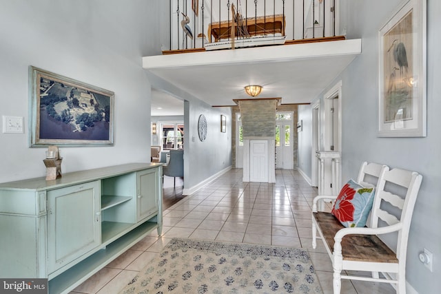 entryway featuring plenty of natural light, baseboards, and light tile patterned floors