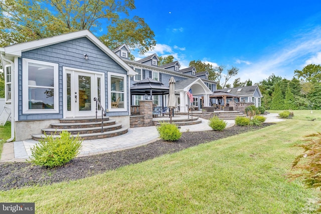 back of property featuring a yard, a gazebo, entry steps, and a patio