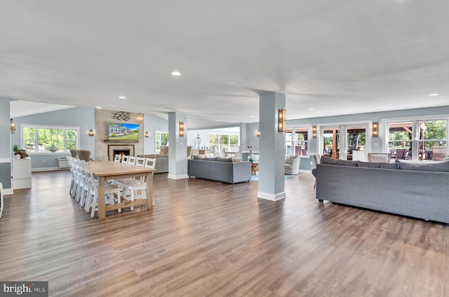 living room featuring wood finished floors, baseboards, and a healthy amount of sunlight