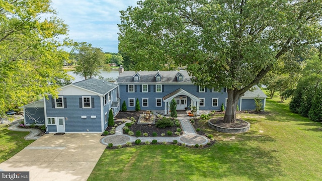 colonial home featuring concrete driveway, a garage, and a front yard