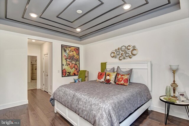 bedroom featuring recessed lighting, a raised ceiling, baseboards, and dark wood-style flooring