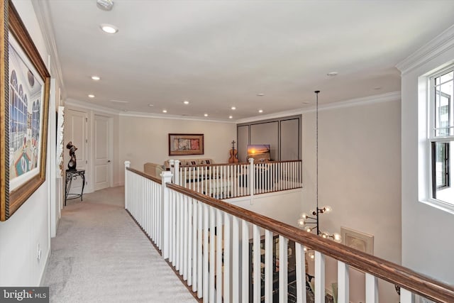 hallway featuring an upstairs landing, light carpet, recessed lighting, a chandelier, and ornamental molding