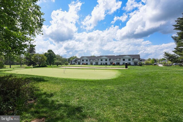 view of community with a putting green and a yard