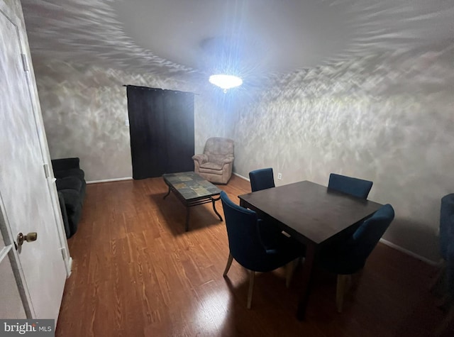 dining space featuring wood finished floors and baseboards