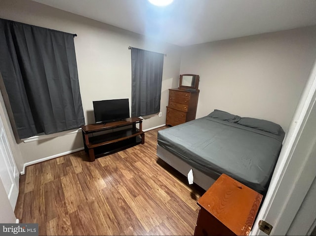 bedroom with baseboards and wood finished floors