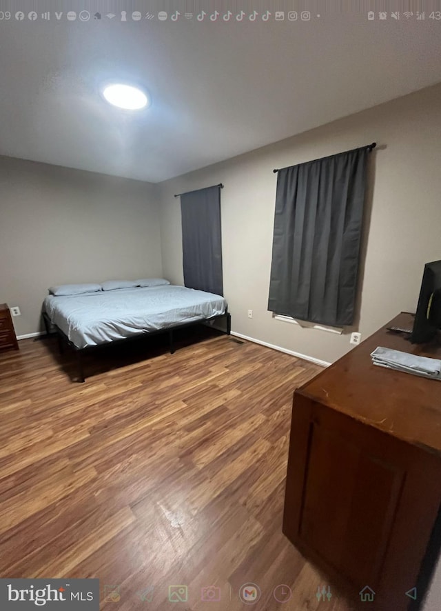 bedroom featuring baseboards and wood finished floors