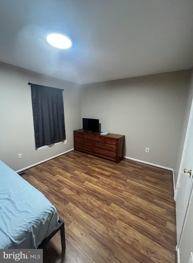 bedroom with wood finished floors and baseboards