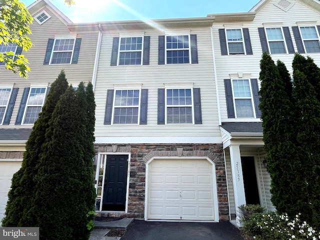 view of property with stone siding and aphalt driveway