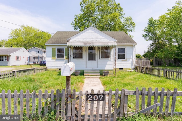 bungalow featuring crawl space, roof with shingles, and a fenced front yard