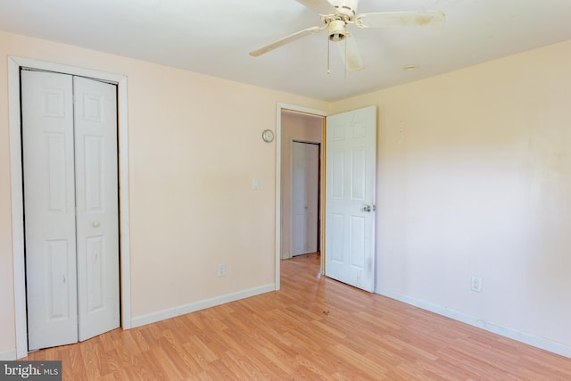 unfurnished bedroom featuring light wood finished floors, baseboards, a closet, and ceiling fan