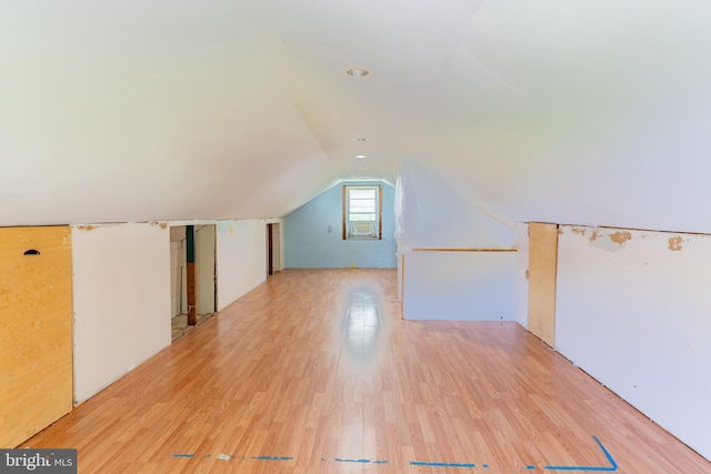 additional living space with wood finished floors and vaulted ceiling