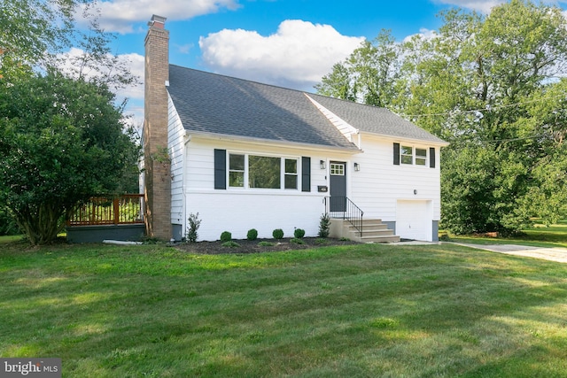 split level home featuring a chimney, a garage, brick siding, a front yard, and a shingled roof