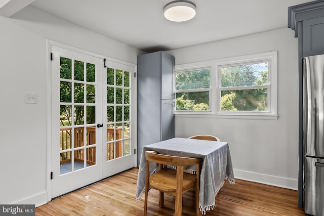 entryway featuring french doors, light wood finished floors, and baseboards