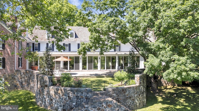 rear view of property with a yard and a patio area