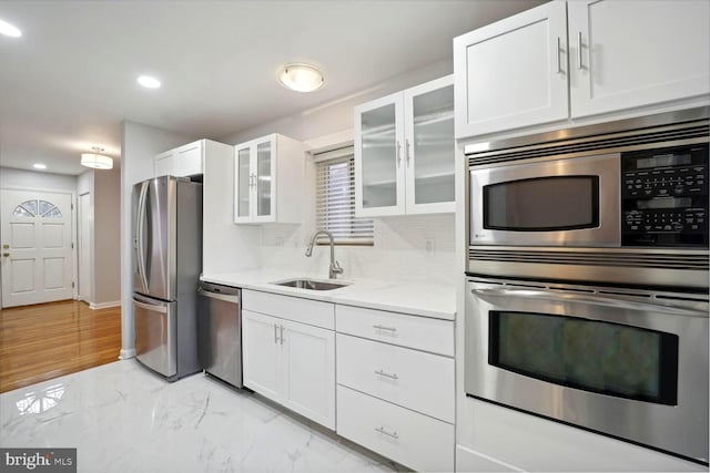 4112 Norcross St, Temple Hills, MD 20748 - kitchen featuring a sink, decorative backsplash, light countertops, white cabinets, and appliances with stainless steel finishes