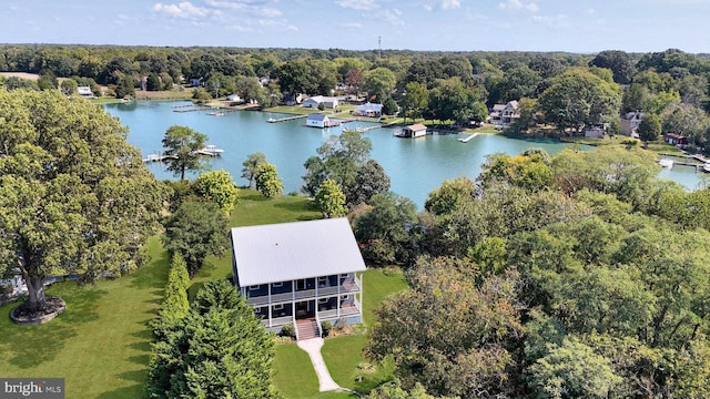 birds eye view of property with a wooded view and a water view