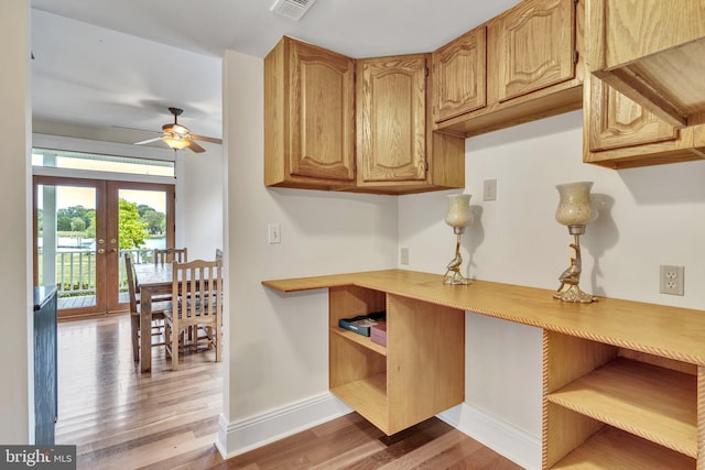 kitchen with french doors, wood finished floors, baseboards, ceiling fan, and light countertops