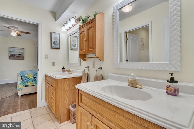 bathroom featuring a ceiling fan, tile patterned floors, two vanities, and a sink
