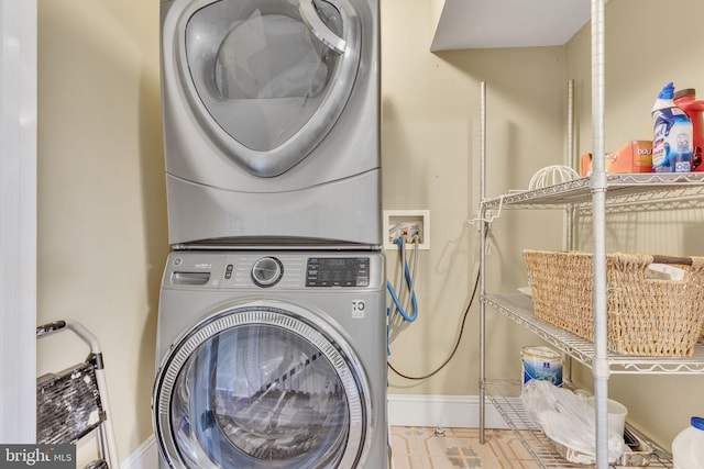 laundry area with laundry area, stacked washer and clothes dryer, baseboards, and tile patterned flooring