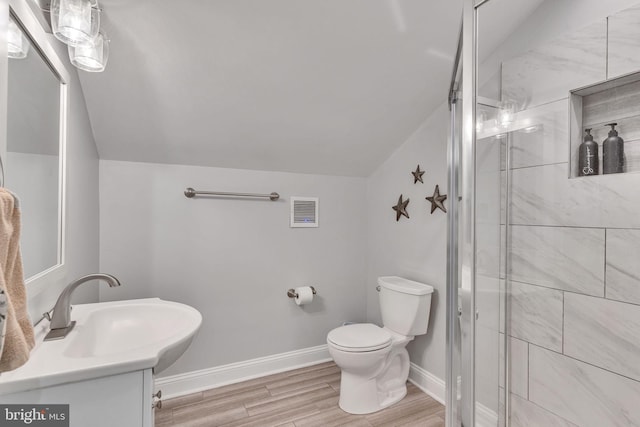 bathroom with toilet, lofted ceiling, wood finished floors, visible vents, and a shower stall