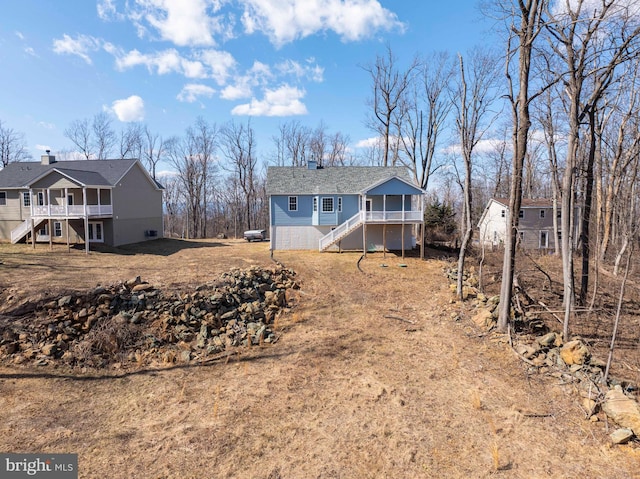 back of property with a deck and stairs