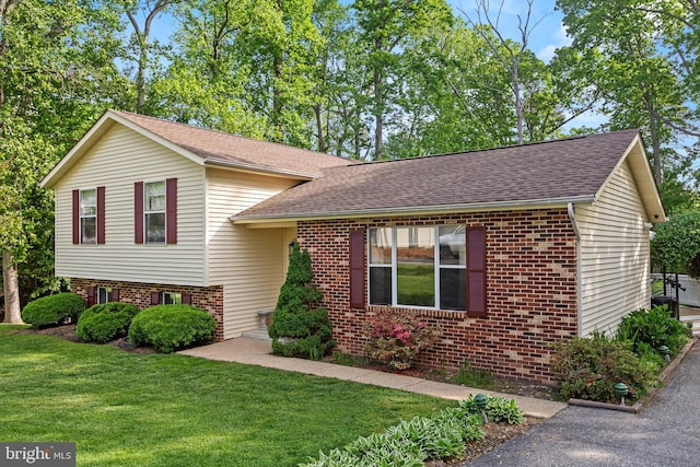 8186 Ebbtide Ln, Lusby, MD 20657 - tri-level home featuring roof with shingles, brick siding, and a front yard