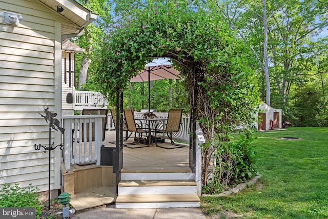 8186 Ebbtide Ln, Lusby, MD 20657 - wooden terrace featuring a yard, an outdoor structure, outdoor dining space, and a storage unit