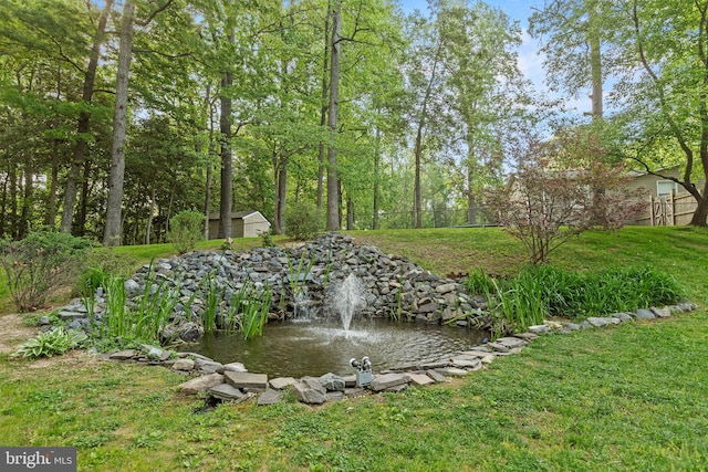 8186 Ebbtide Ln, Lusby, MD 20657 - view of yard featuring fence, an outbuilding, a storage shed, and a garden pond