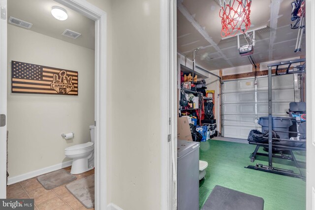 garage featuring washer / clothes dryer, baseboards, visible vents, and a garage door opener
