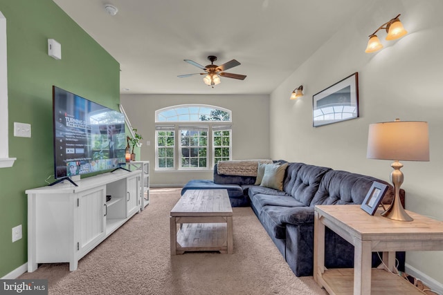 living area featuring ceiling fan, light carpet, and baseboards