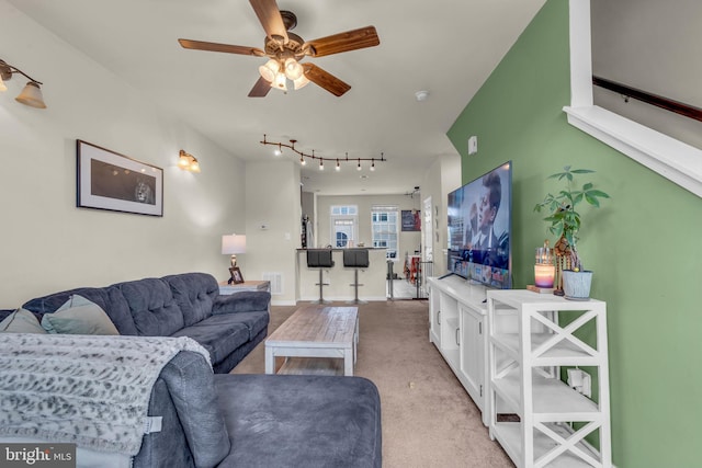 living area featuring light colored carpet, a ceiling fan, track lighting, and visible vents