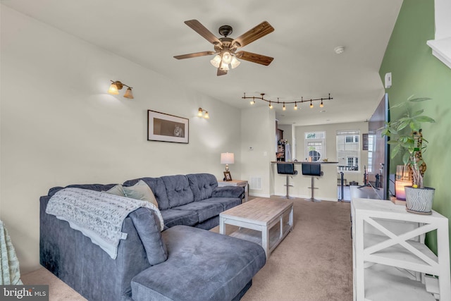 living room with a ceiling fan, baseboards, visible vents, track lighting, and carpet floors