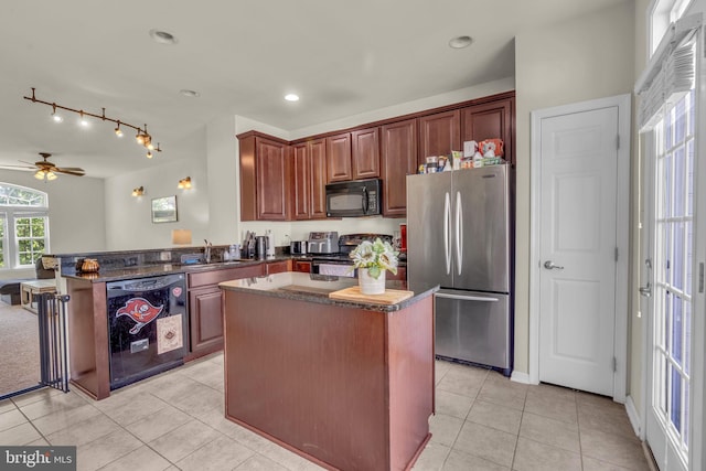 kitchen featuring a sink, a peninsula, light tile patterned flooring, and black appliances