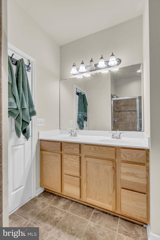 bathroom with a sink, double vanity, and a tile shower