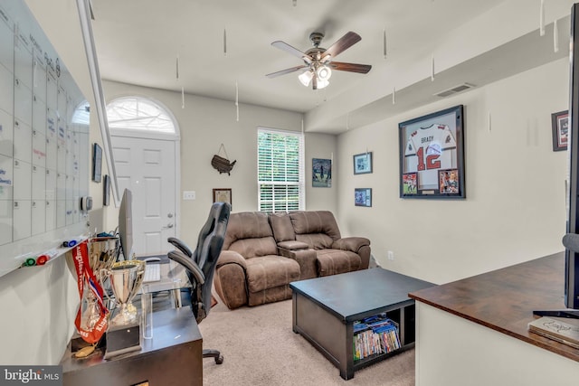living room with attic access, visible vents, a ceiling fan, and carpet