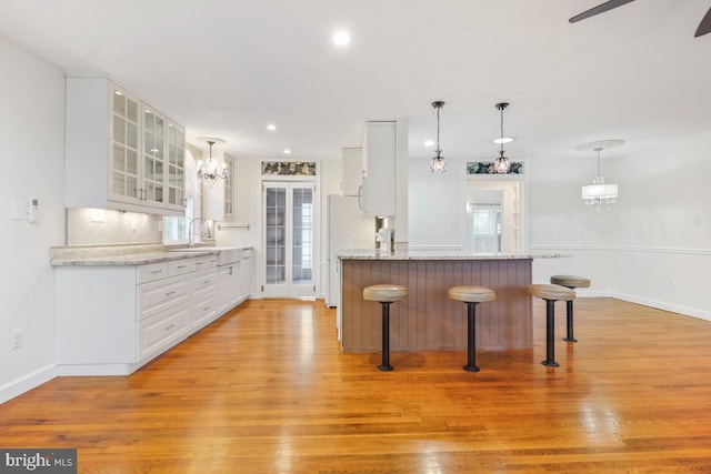 905 Burke Dr, Woodbridge, VA 22191 - kitchen with light wood finished floors, a kitchen bar, white cabinets, and recessed lighting