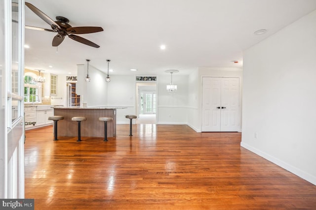 905 Burke Dr, Woodbridge, VA 22191 - kitchen with a breakfast bar, wood finished floors, a center island, white cabinets, and ceiling fan