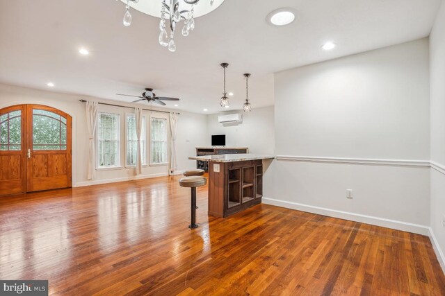 905 Burke Dr, Woodbridge, VA 22191 - unfurnished living room with a wall mounted AC, recessed lighting, wood finished floors, and baseboards